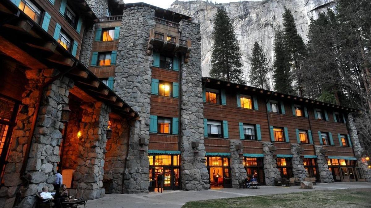 The historic Ahwahnee Hotel, lit up as dusk falls over Yosemite Valley, will soon change its name in an ongoing battle over who owns the intellectual property.