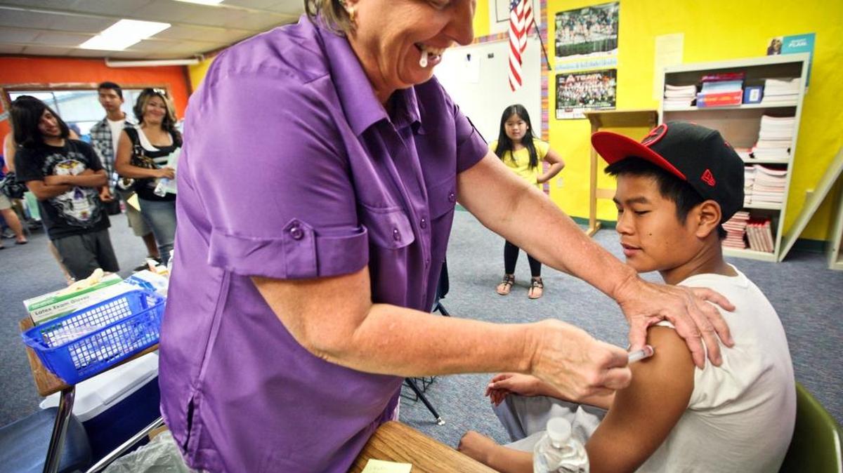Fresno Unified nurse practitioner Kathy Davis administers the Diphtheria-Tetanus-Acellular Pertussis or Tdap vaccination to Hoover High student Billy Kongphouthakhoun, 16, on July 16, 2011. District trustees voted last week to open health centers at six schools in a partnership with Valley Children’s Healthcare and Clinica Sierra Vista.