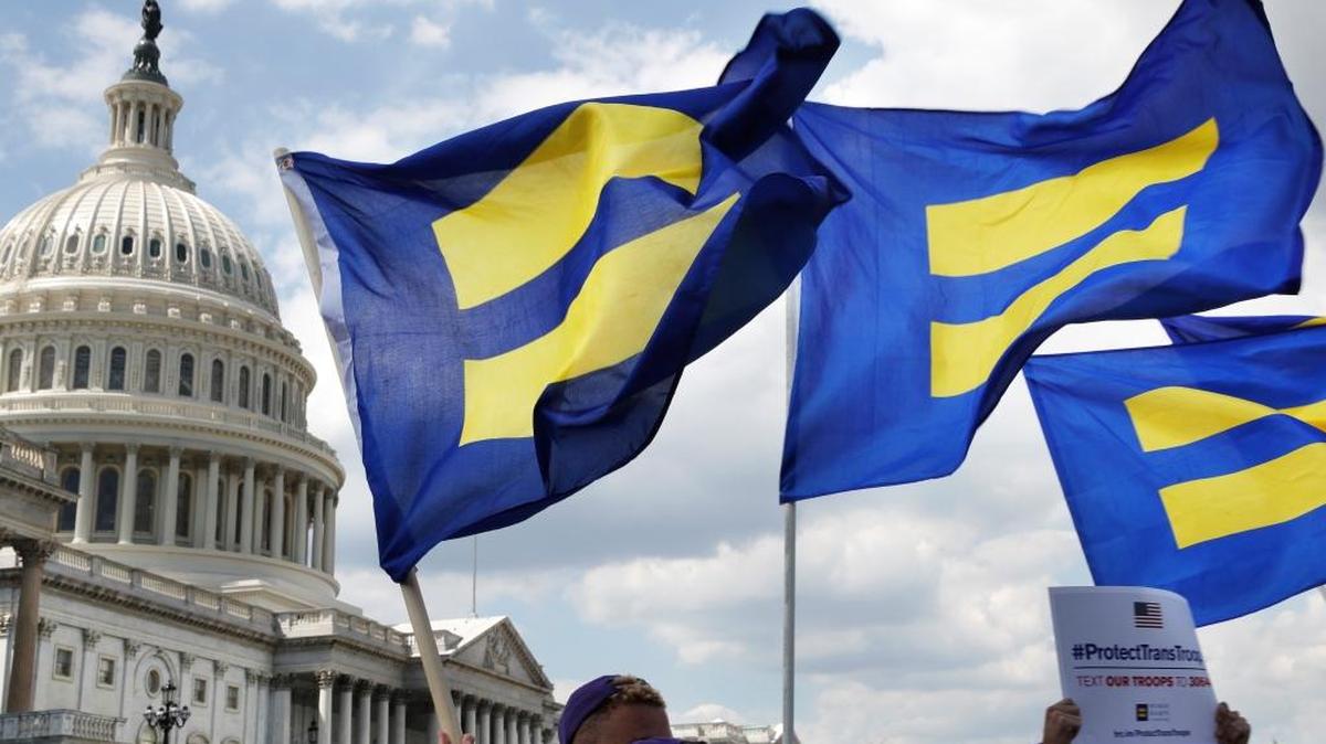 Activists with the Human Rights Campaign hold up equality flags in support of transgender members of the military on Wednesday on Capitol Hill after President Donald Trump said he wants to ban transgender people from serving.