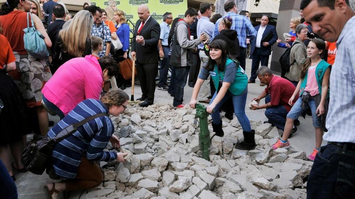 Girl Scout Miranda Deis, 10, center, poses for a photo with a jackhammer following the groundbreaking ceremony for reopening the Fulton Mall to vehicular traffic March 3, 2016. Garnering support and funding for the project required Mayor Ashley Swearengin to be persistent in the face of community opposition.