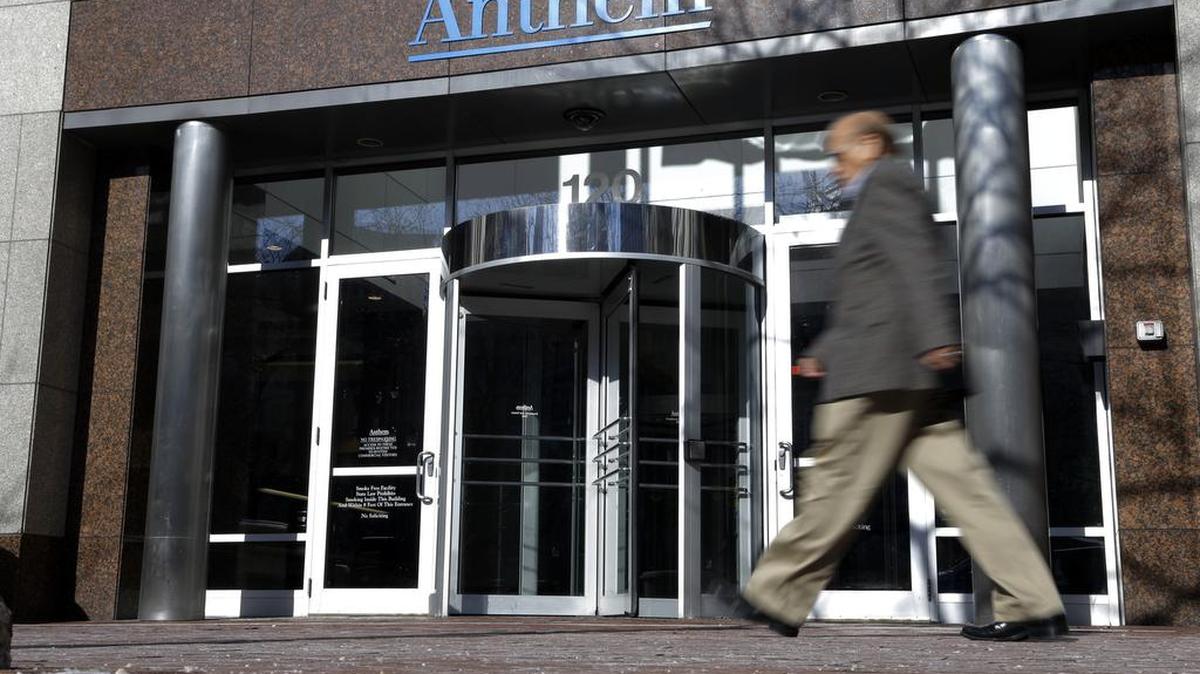 A man walks past health insurer Anthem’s corporate headquarters in Indianapolis. The health insurance giant wants to merge with Cigna, in one of two mega-deals in the industry the Justice Department has sought to block.