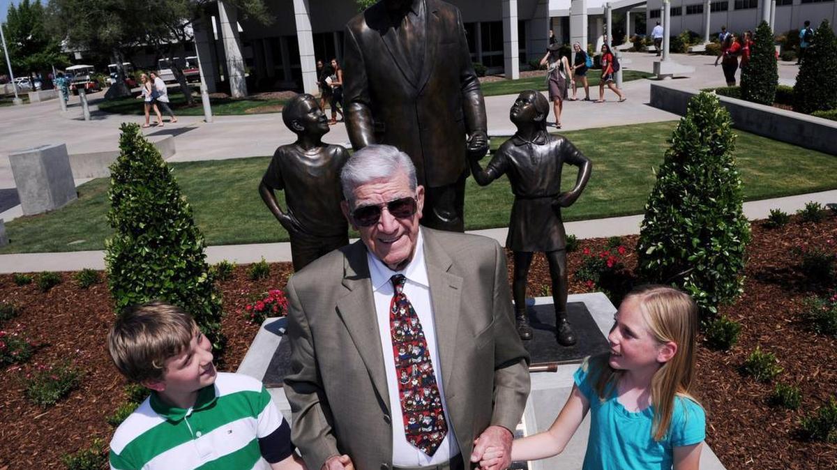 
Floyd “Doc” Buchanan, stands in front of the statue depicting him with William McGrady, left, and Sophia Poduska, right, during the dedication ceremony May 24, 2012, at Buchanan High School. 
