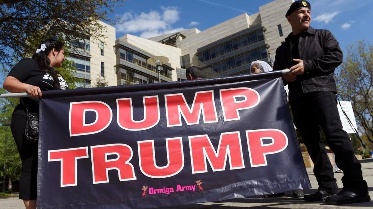 Juan Avitia, right, helps hold a sign at Tulare and O streets as approximately 50 people from about four groups gathered outside the Robert E. Coyle Federal Building in March calling for voters to vote for someone other than Donald Trump. We agree.