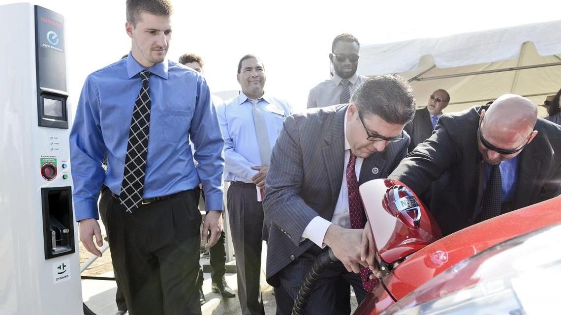 Fresno State president Joseph Castro, center, gets help plugging into an electric-car charging station from project coordinator Devon Fullner, right, at the station’s opening May 6. 2015. The station is at Fresno State just west of the Save Mart Center. The station is open to the public and costs a flat rate of $1 per hour.
