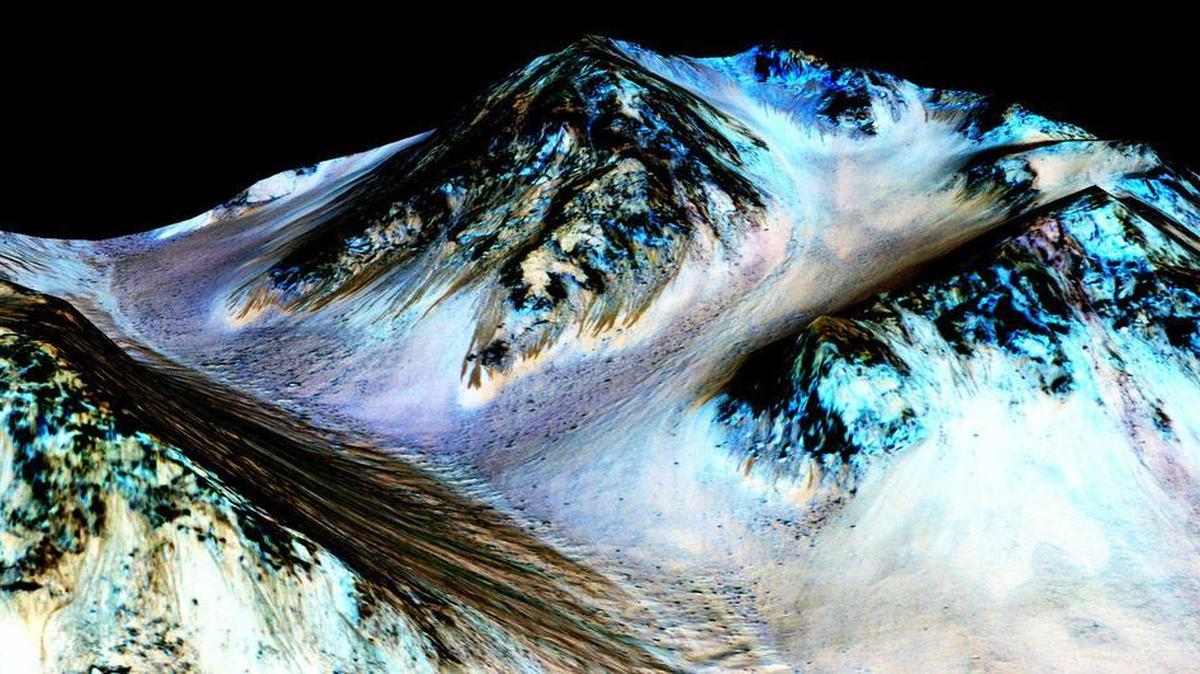 
This photo taken by the Mars Reconnaissance Orbiter shows dark, narrow, 100 meter-long streaks on the surface of Mars that scientists believe were caused by flowing streams of salty water. 
