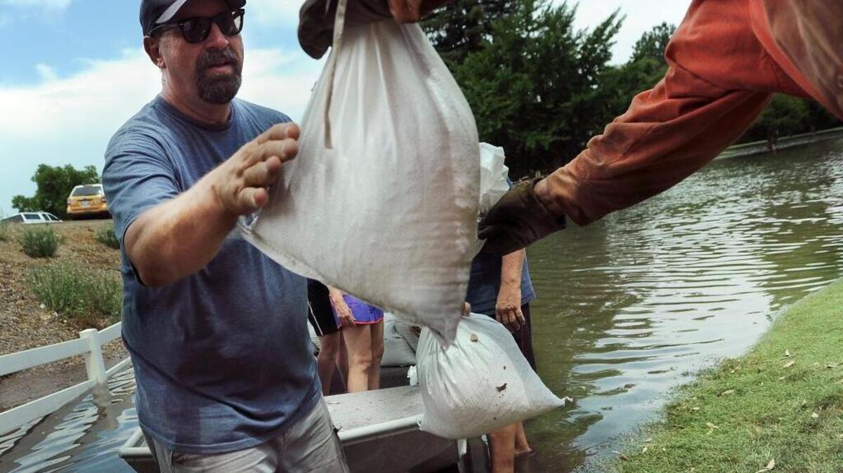 Mark Joseph receives filled sandbags from inmates before he took them by boat to where the river broke at the Kings River Golf and Country Club on June 24, 2017, east of Kingsburg.