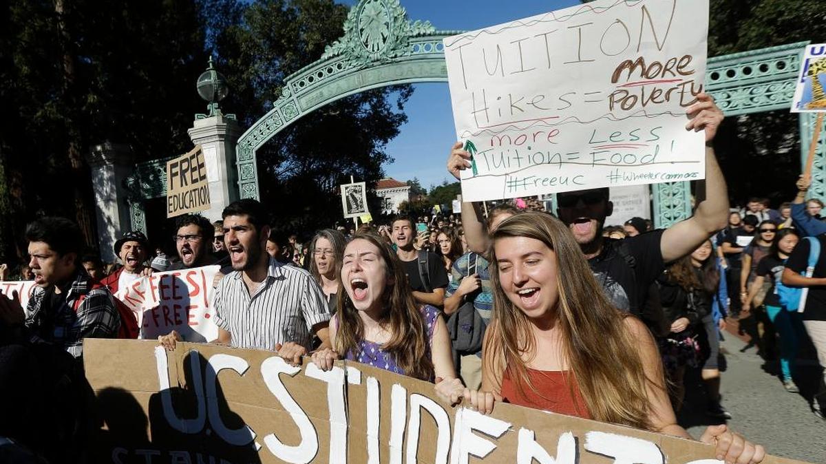 In this Nov. 24, 2014, file photo, Caitriona Smyth, center, yells as she and other students march under Sather Gate during a protest against tuition increases at UC Berkeley. Now, as record numbers of high school graduates in California qualify for admission, the UC and CSU systems are considering raising tuition for the first time in six years.