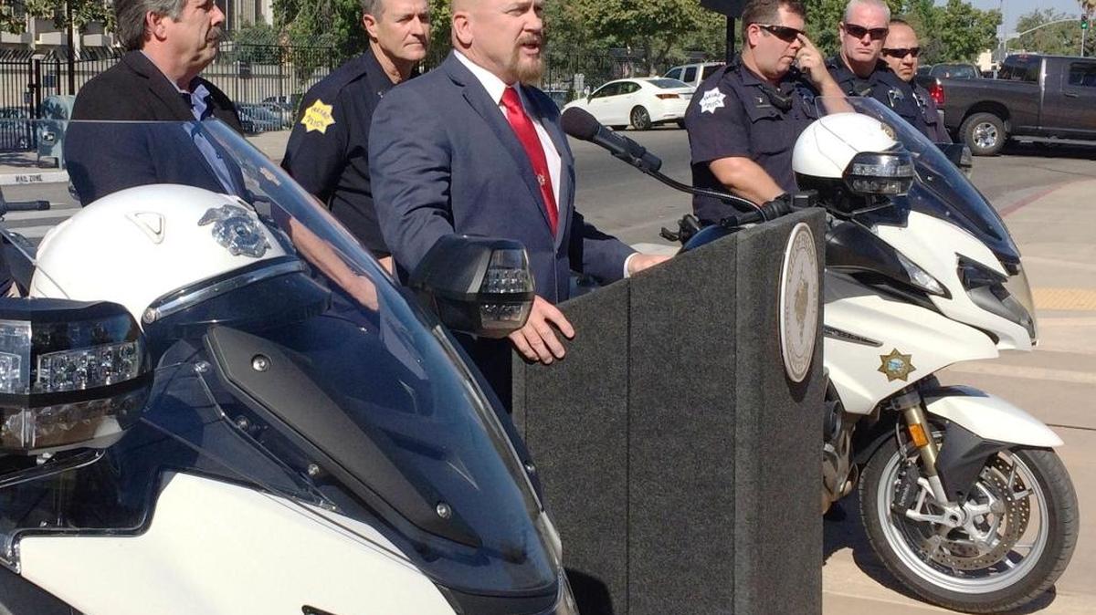 Fresno City Manager Bruce Rudd, far left, and Fresno police Capt. Andy Hall, second from left, and several Fresno police motorcycle officers listen outside Fresno City Hall as Councilman Steve Brandau discusses a two-week litter-enforcement effort Sept. 19.