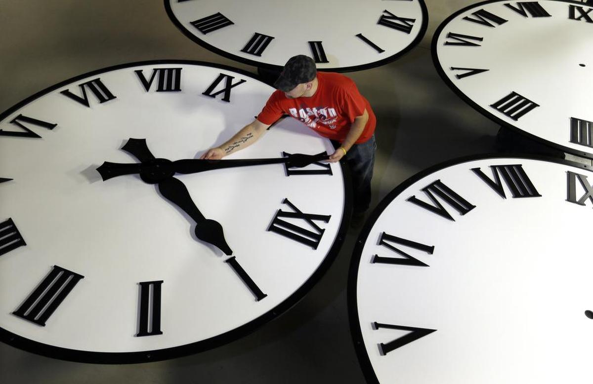 Dan LaMoore sizes hands for an 8-foot diameter silhouette clock at Electric Time Co., in Medfield, Mass. Proposition 7, passed in November 2018, asked California voters to make daylight saving time year-round.