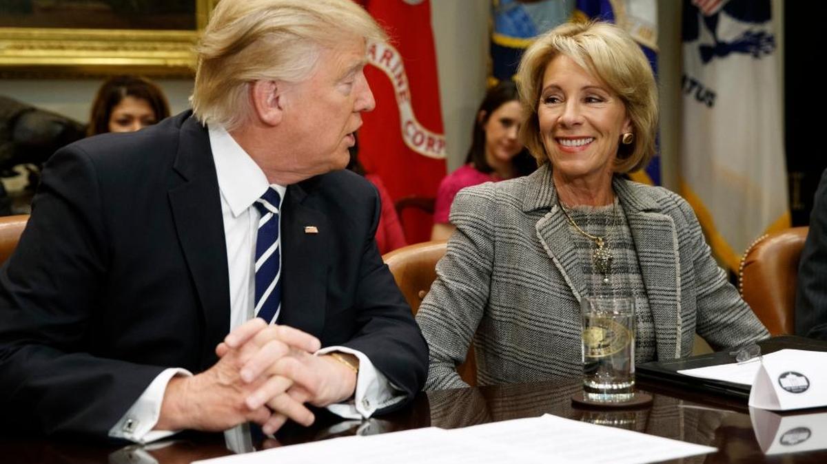 President Donald Trump talks to Education Secretary Betsy DeVos in the Roosevelt Room of the White House in Washington.