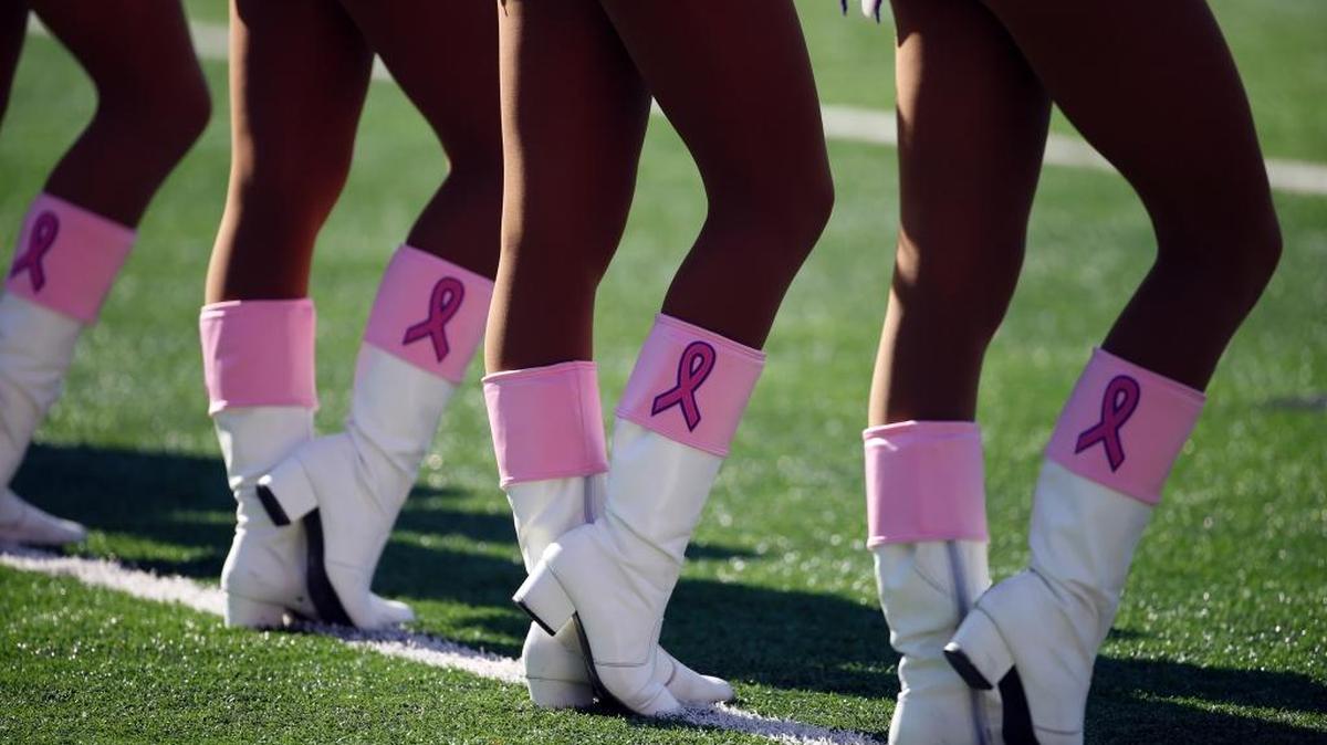 The Minnesota Vikings cheerleaders perform with pink ribbons on their boots for breast cancer awareness.