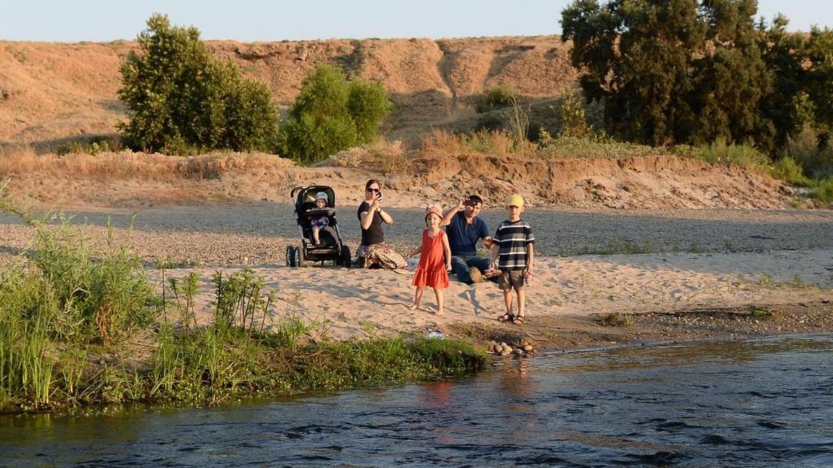 A family sits enjoys the views of the San Joaquin River on a bank just north of Fresno.