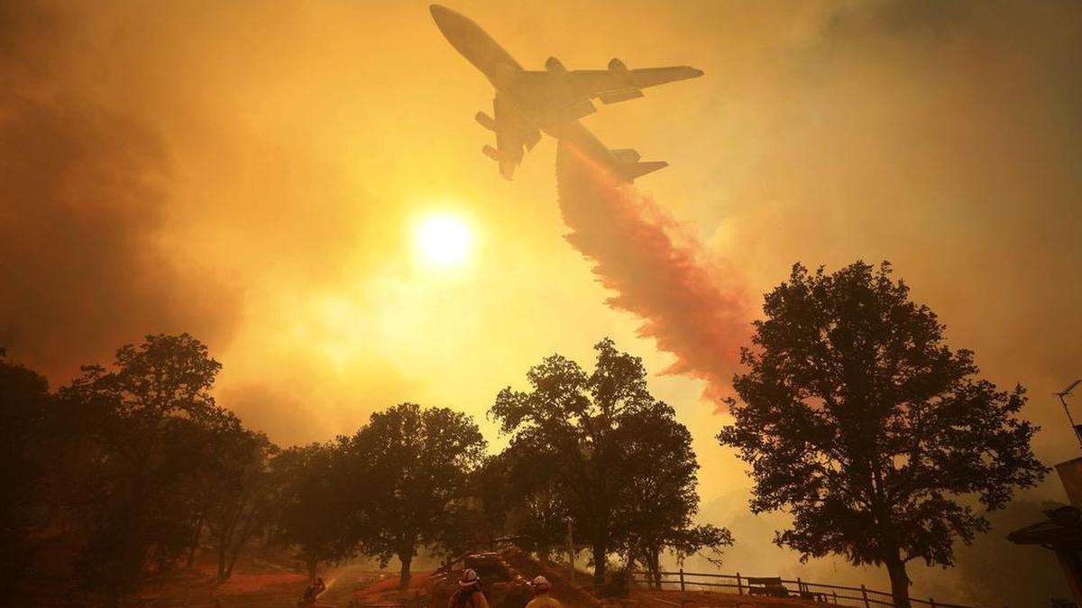 A 747 Global Airtanker makes a drop in front of advancing flames from a wildfire Thursday, Aug. 2, 2018, in Lakeport, Calif.