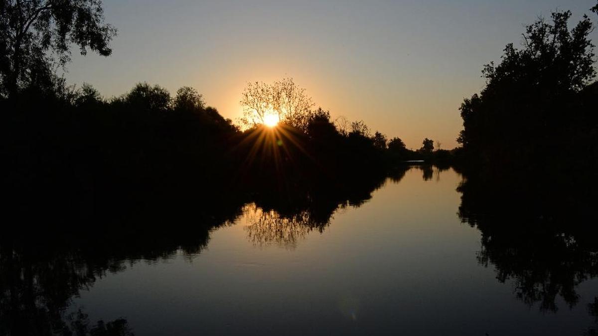 The sun begins to set looking west on the San Joaquin River just north of Fresno in this 2017 photo.