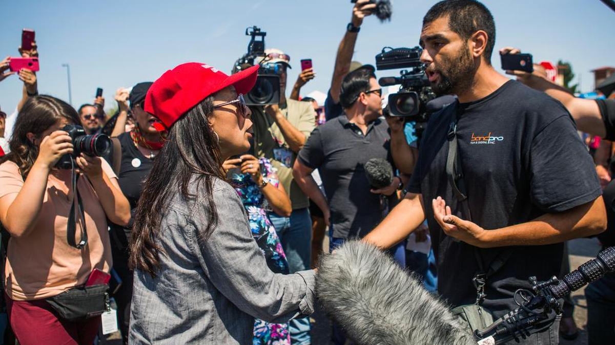 A woman wearing a “Make America Great Again” hat argues with people opposed to President Donald Trump’s visit on Wednesday, Aug. 7, 2019, at the makeshift memorial for the victims of the mass shooting on Saturday at a Walmart store in El Paso, Texas.