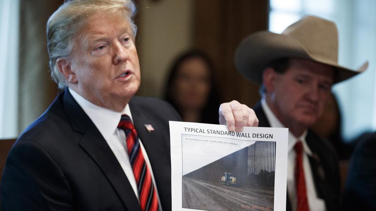 President Donald J. Trump presents a “typical standard wall design” as he participates in a roundtable discussion on border security and safe communities with state, local and community leaders in the Cabinet Room of the White House on Jan. 11.