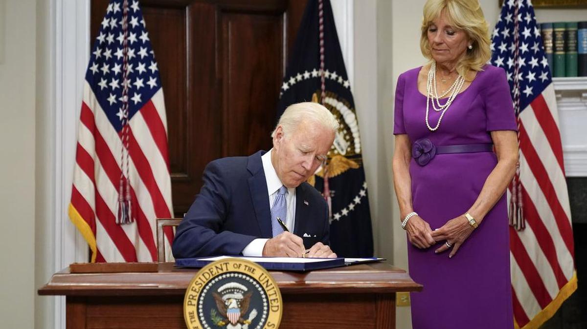 President Joe Biden signs into law S. 2938, the Bipartisan Safer Communities Act gun safety bill, in the Roosevelt Room of the White House in Washington, Saturday, June 25, 2022. First lady Jill Biden looks on at right.