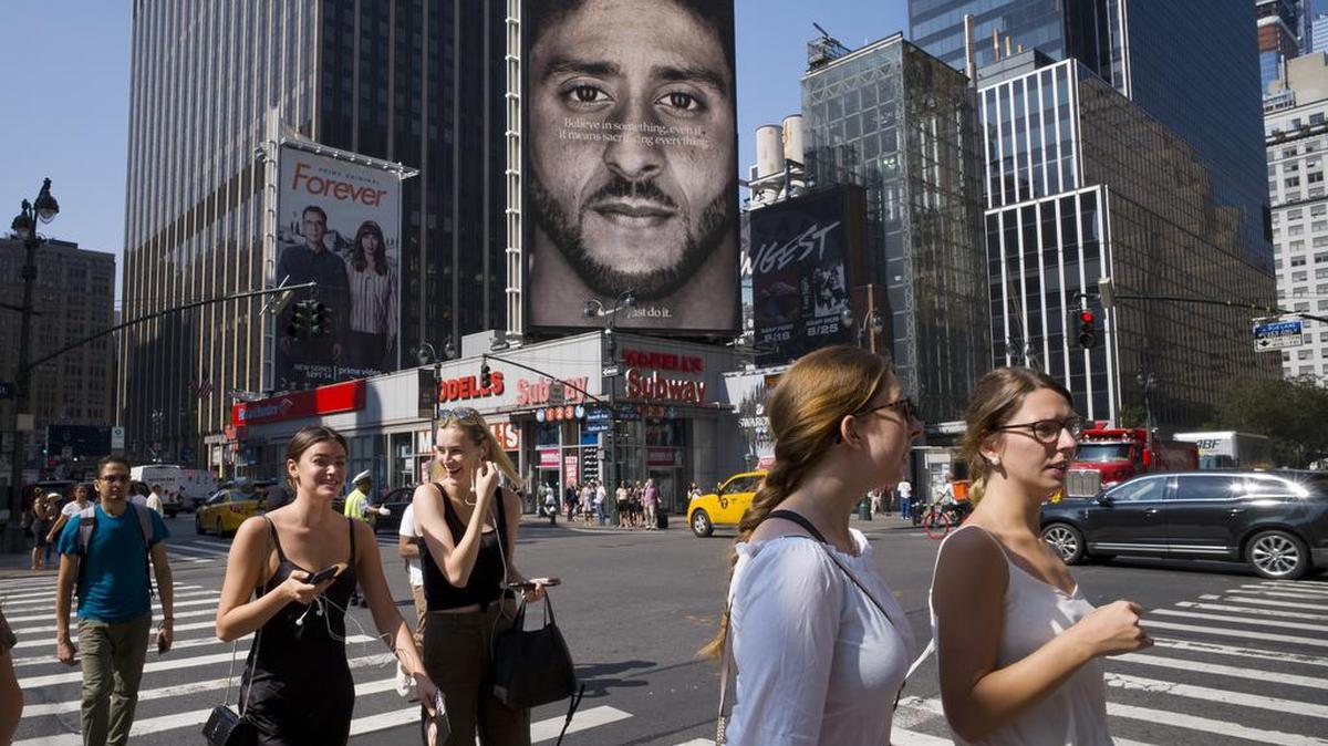 People walk by a Nike advertisement featuring Colin Kaepernick on display, Thursday, Sept. 6, 2018, in New York. Nike unveiled the deal with the former San Francisco 49ers quarterback, who’s known for starting protests among NFL players over police brutality and racial inequality.