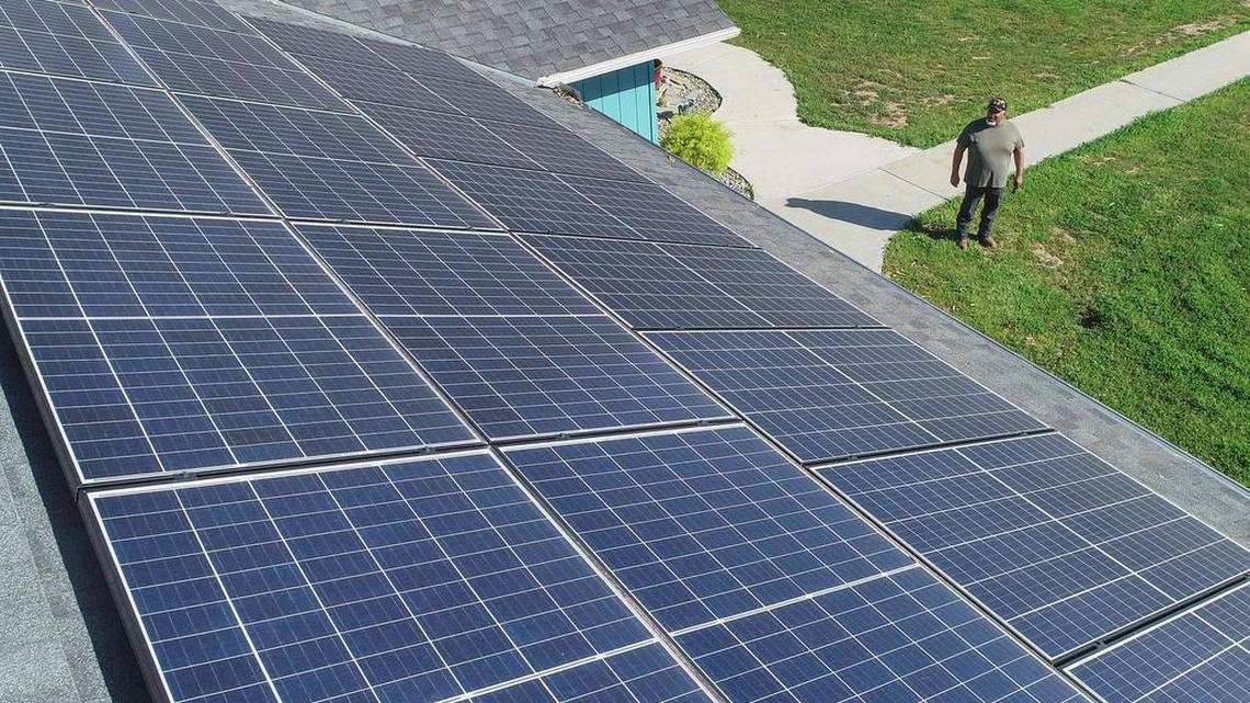 Ramon Torres, who lives in the Madera Ranchos area of Madera County, looks up at the solar panels covering the top of his roof on Friday, March 27, 2021.