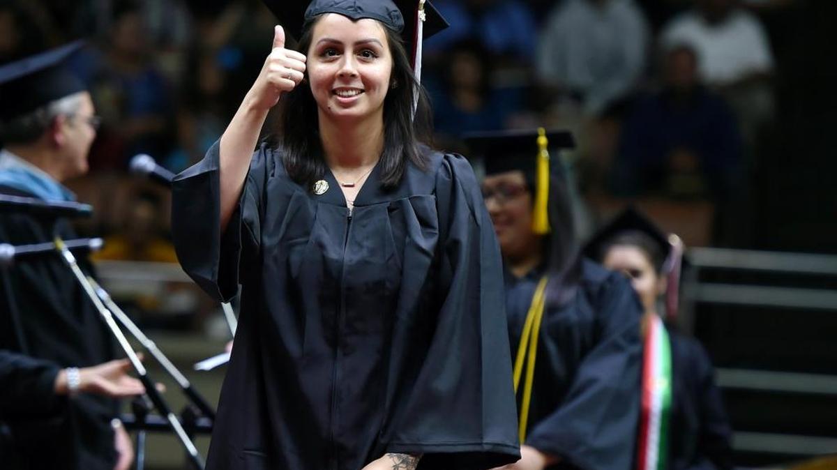 Michelle Zamora gives a thumbs up as she walks across the stage during Fresno City College’s commencement ceremony at Selland Arena on May 20, 2016. Officials said the graduating class of 1,487 students was the largest in Fresno City College history.