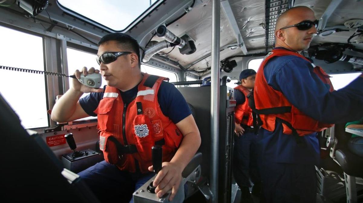 In this Jan. 28, 2014, photo, Coast Guard officer William Pless communicates on the radio while steering the 45-foot Coast Guard vessel through a dense fog during a patrol off the San Diego coast. Smugglers carry multi-ton loads of cocaine and marijuana hundreds of miles offshore, where the lead federal agency with extensive law enforcement powers is the Coast Guard, a military service roughly the size of the New York Police Department.