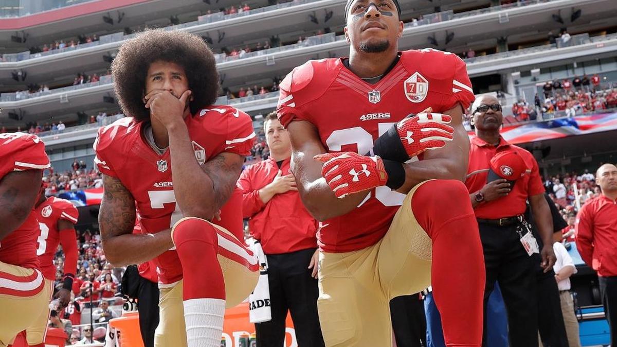 San Francisco quarterback Colin Kaepernick, left, and safety Eric Reid kneel during the national anthem before an NFL football game.