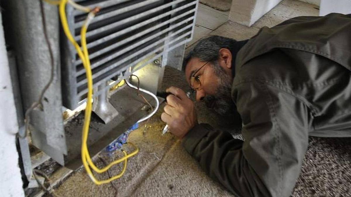 In 2016, city code enforcement inspector John Tanksley examines a broken heater – improperly hooked up and with bare wires exposed – at a Fresno apartment complex. The city is planning a stronger rental housing inspection program but said Oct. 26 that its start is delayed until early 2018.