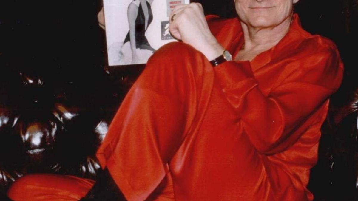 Hugh Hefner relaxes in red satin pajamas with the first copy of Playboy magazine, the then-scandalous men's magazine he founded in the 1950s, in his Holmby Hills estate in Los Angeles recently. Actress Marilyn Monroe was featured in the first issue in 1953. Hefner was known to have made red silk pajamas into office attire.