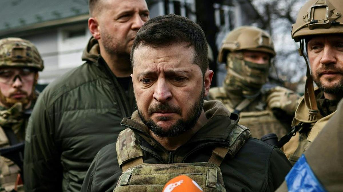Ukainian President Volodymyr Zelensky, center, speaks to the press in the town of Bucha, northwest of the Ukrainian capital Kyiv, on Monday, April 4, 2022.