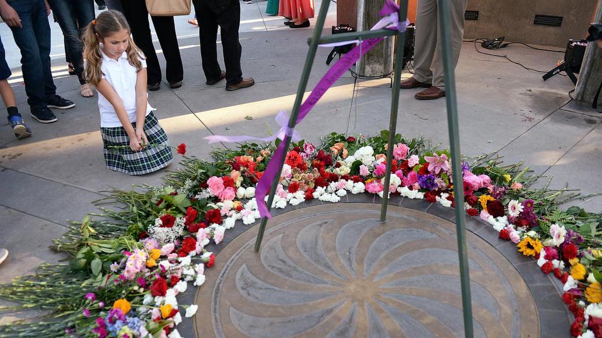 Julie Sabiljian, 9, of Fresno places a flower at the base of the Armenian Genocide Memorial at Fresno State before a commemorative event in 2018 to observe the 103rd anniversary of the Armenian Genocide.