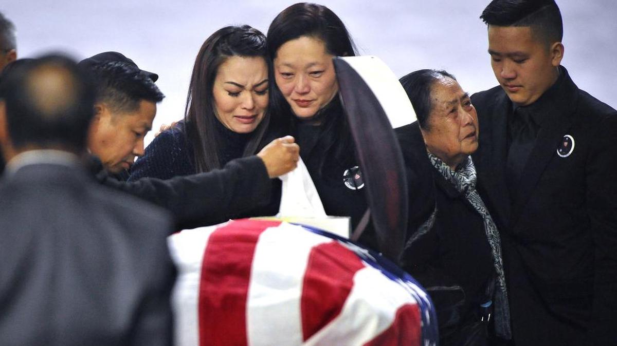 Mourners including family members gather around Ker Vang, center, at the casket of her husband, Fresno police officer Phia Vang, on the first day of his three-day funeral services at the Fresno Convention Center Exhibit Hall on Friday Feb. 22, 2019. Vang was killed several weeks ago by a wrong-way driver.