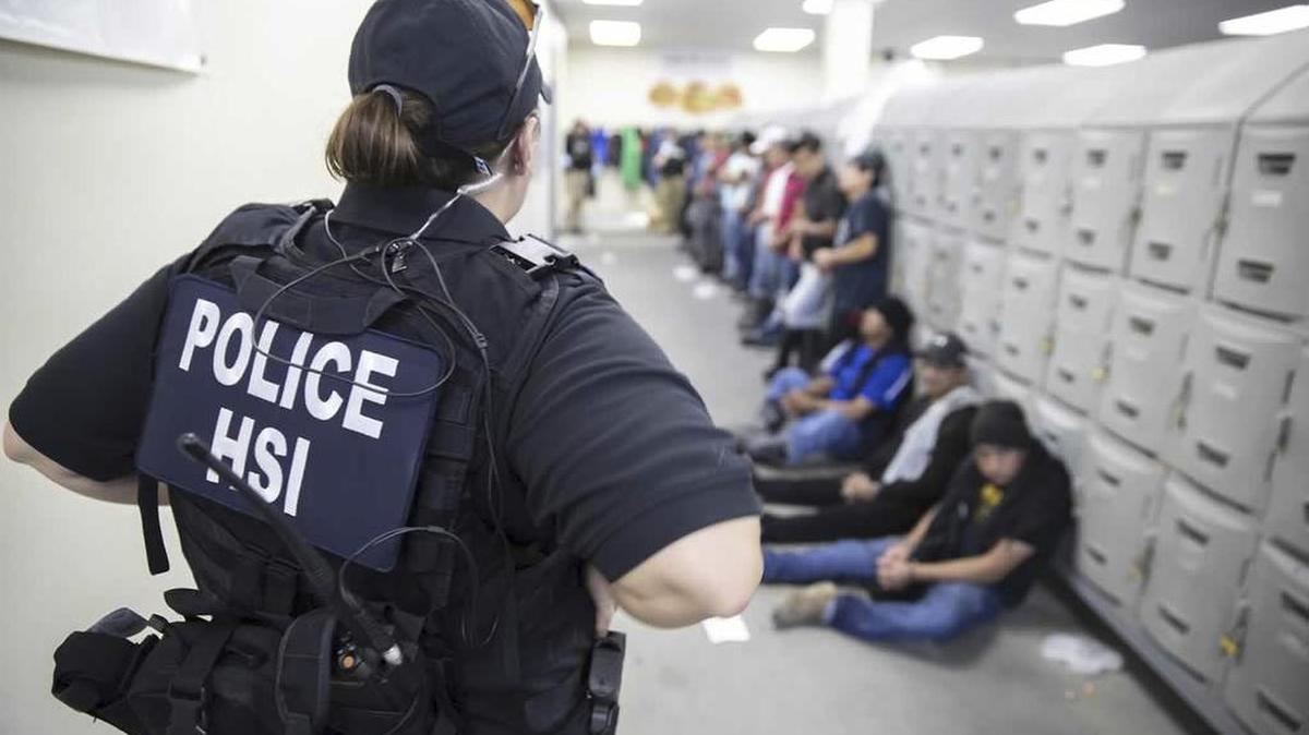 Homeland Security ICE enforcement officers detain workers at a poultry processing plant on Aug. 7 in Jackson, Miss. U.S. immigration officers raided several Mississippi food processing plants, detaining 680 undocumented workers.