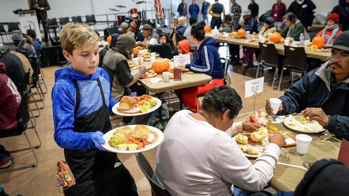 William Bartel, 12, of Clovis helps serve meals to homeless and needy while volunteering with his family at the Fresno Rescue Mission during their annual Thanksgiving Luncheon on Tuesday, Nov. 26, 2019. The event was open for anyone in the community to enjoy a traditional thanksgiving meal including turkey, stuffing, potatoes, vegetables and pumpkin pie. The program included music and a short message.