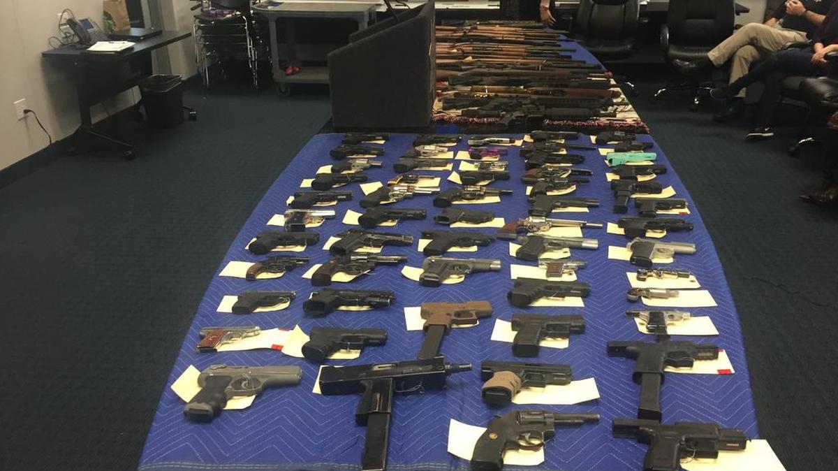 Handguns and assault pistols, some with high-capacity magazines outlawed in California, were displayed by Fresno police following sweeps of reputed gang members.