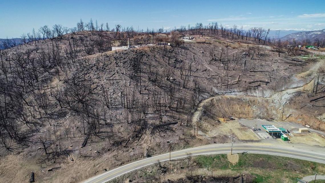 Cressman’s General Store, destroyed in last year’s Creek Fire, and the remains of its gas station appear at lower right while surrounded by mostly charred terrain along Highway 168 above the four-lane section near Pine Ridge in this drone image on Friday, April 9, 2021.