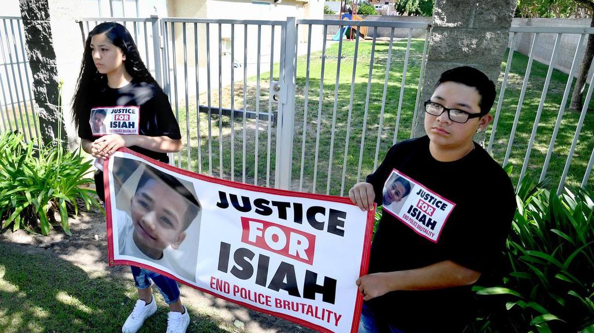 Family members of Isiah Murrietta-Golding stand in front of a play area at New Life Discovery School, 420 E. Keats Ave., where the teenager was fatally shot in the back of the head by a Fresno Police officer, in April 2017.