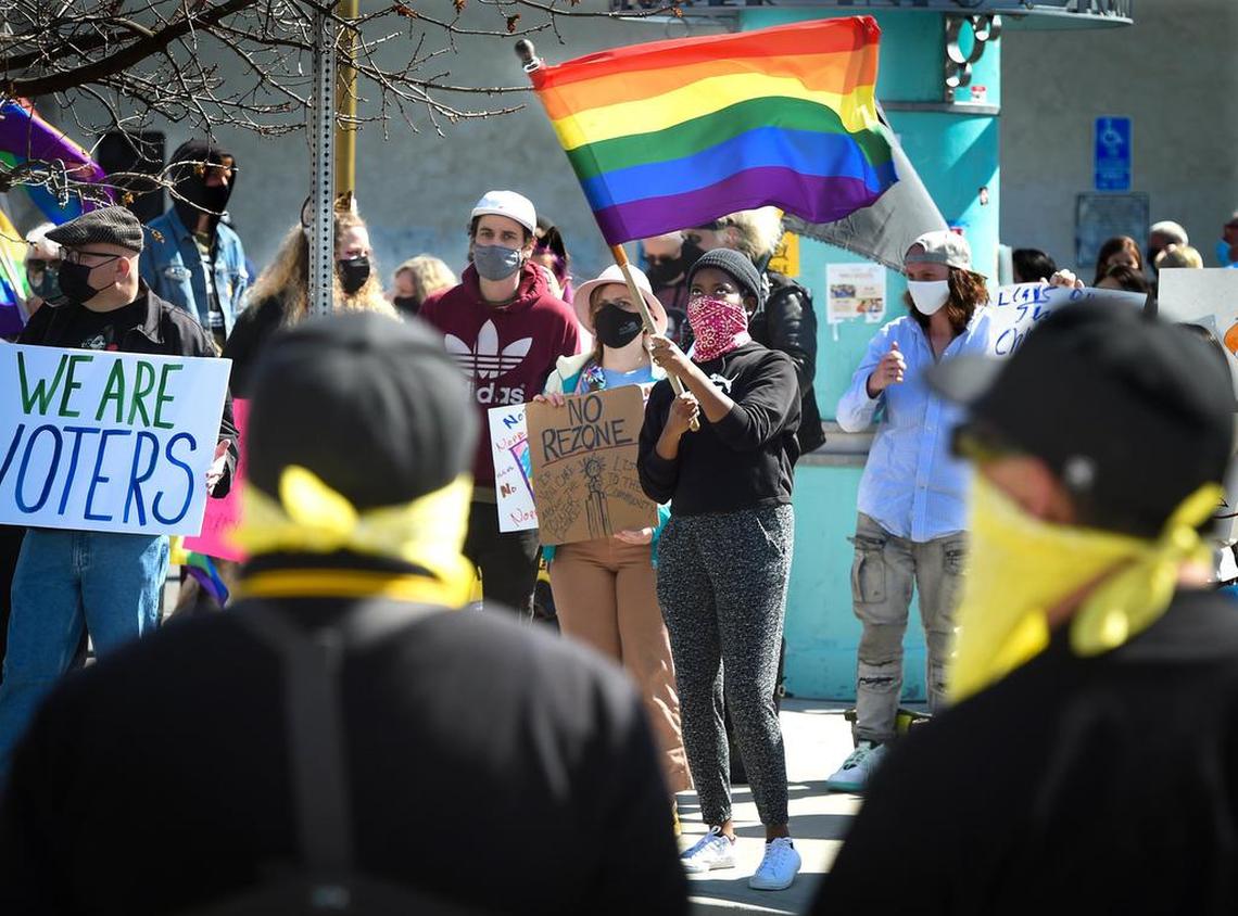 Lucy Schmidt, among around 200 protesting the sale of the historic Tower Theatre to Adventure Community Church waves her rainbow flag across the street from a small group of protesters wearing the colors and insignias of the Proud Boys and Oath Keepers, standing in front of the theater, March 21, 2021.