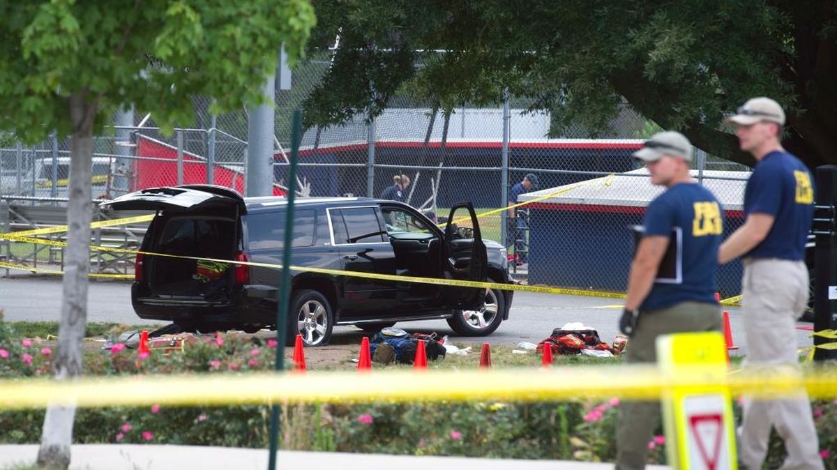 An SUV, with a bullet hole in the windshield and a flat tire, sits in the parking lot at the scene of the multiple shooting in Alexandria, Va., June 14, 2017, involving House Majority Whip Steve Scalise of La., and others, during a congressional baseball practice.