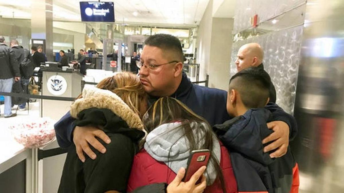 In this Monday, Jan. 15, 2018 photo, Jorge Garcia hugs his wife, Cindy Garcia, and their two children at Detroit Metro Airport moments before boarding a flight to Mexico. Garcia, who had lived in the U.S. for nearly 30 years, was deported to Mexico. Detroit Free Press via AP Niraj Warikoo