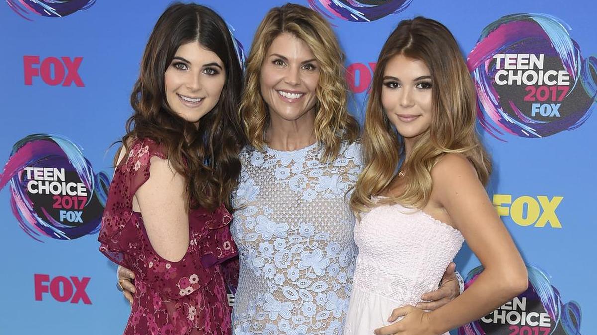 In this Aug. 13, 2017 photo, actress Lori Loughlin, center, poses with her daughters Bella, left, and Olivia Jade at the Teen Choice Awards in Los Angeles. The FBI says Lori Loughlin was taken into custody in connection with a scheme in which wealthy parents paid bribes to get their children into top colleges.