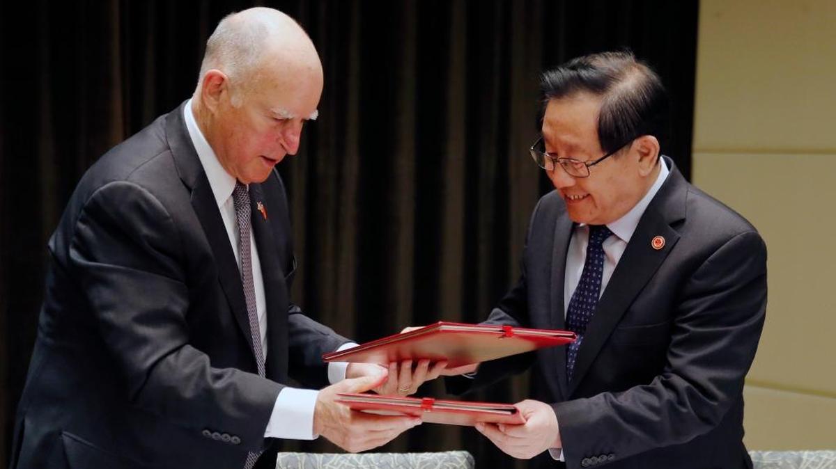 California Gov. Jerry Brown, left, exchanges memorandum of understanding with China’s Science and Technology Minister Wan Gang after the Clean Technology signing ceremony at a hotel in Beijing, June 6, 2017.