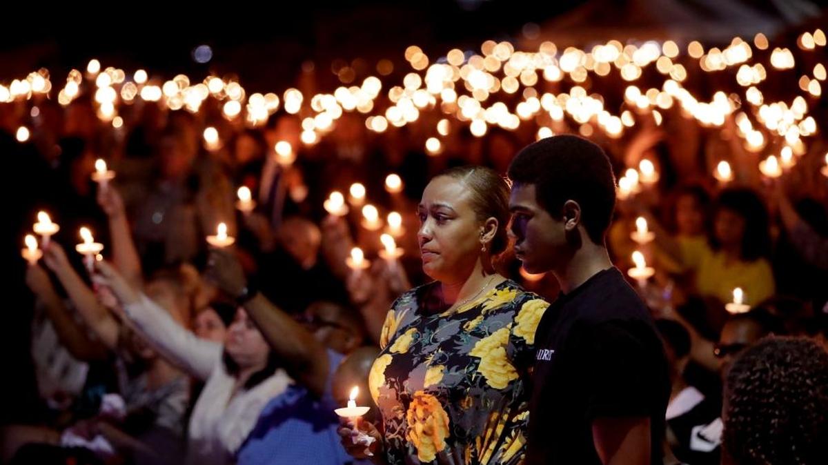 Veronica Hartfield, stands with her son, Ayzayah Hartfield during a candlelight vigil for her husband, Las Vegas police officer Charleston Hartfield, Oct. 5, 2017, in Las Vegas. Hartfield was killed during the Sunday night shooting at the Route 91 Harvest country music festival.