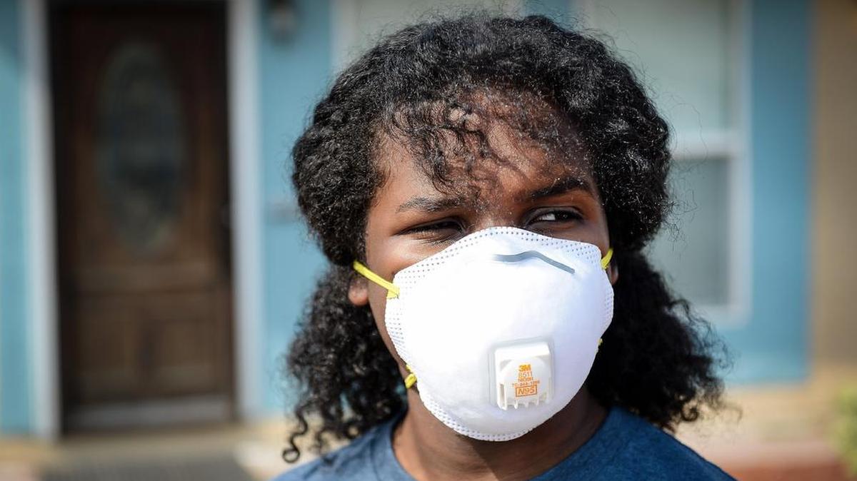 Dyami Hunt, 14, who has asthma and was recovering from walking pneumonia, wears a mask to filter the smokey air while spending time outdoors near his home in Fresno last August.
