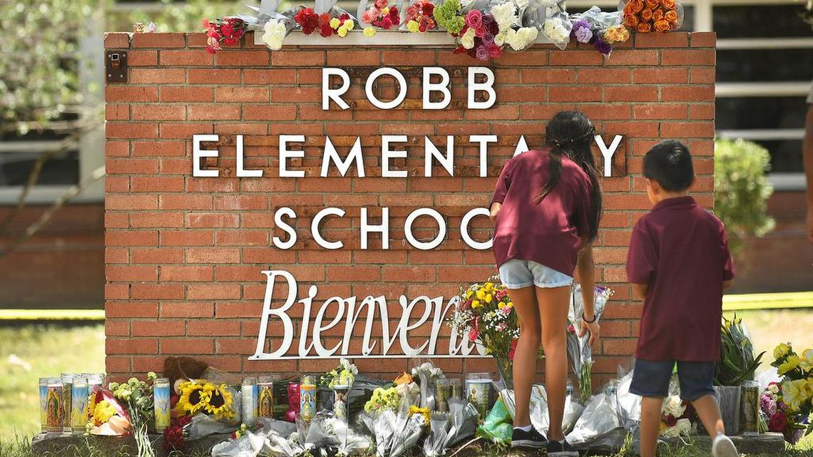Family members who lost a sibling to a gunman’s shooting rampage place flowers outside Robb Elementary School in Uvalde, Texas, on May 25. (Wally Skalij/Los Angeles Times/TNS)