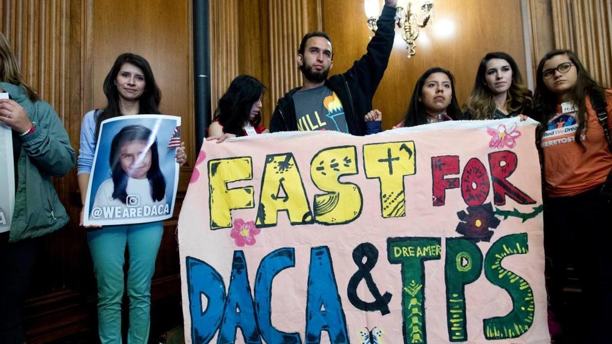 People hold their pictures and a banner during the House and Senate Democrats, news conference on Capitol Hill in Washington Wednesday. House and Senate Democrats gather to call for Congressional Republicans to stand up to President Trump's decision to terminate the Deferred Action for Childhood Arrivals (DACA) initiative by bringing the DREAM Act for a vote on the House and Senate Floor.
