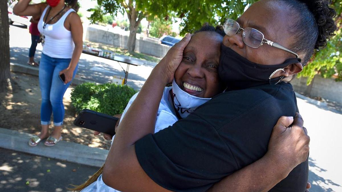 Church of the Living God Associate Pastor Vicky Alberty, right, hugs parishioner Tina Dowell after the church’s prayer rally called 6 Feet In The Street, referring to social distancing, on Saturday, June 27, 2020. Alberty says she believes in the efforts being made in the Black Lives Matter movement, such as marches and rallies, but feels that reaching out to God in prayer is an important part of finding solutions to problems facing the Black population, as well as facing the COVID-19 crisis.