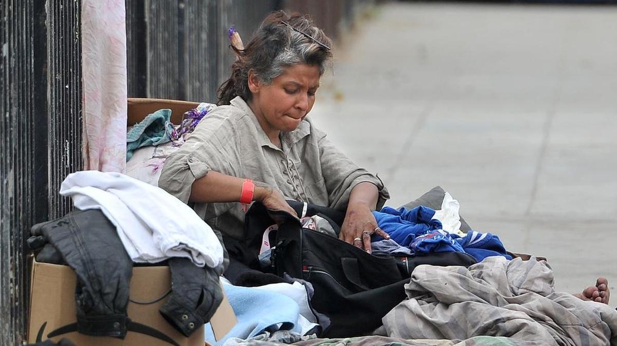 Near the Poverello House, a homeless woman sorts her belongings, Monday April 8, 2019.