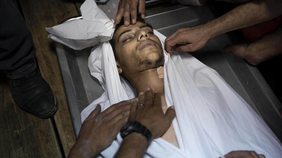 Palestinians gather around of the body of a man killed during a protest on the Erez border crossing with Israel, in a morgue in Beit Lahiya, northern Gaza Strip, Tuesday, Sept. 18, 2018. Gaza’s Health Ministry says two Palestinians have been killed by Israeli fire at a protest near a crossing point between the enclave and Israel. (AP Photo/Felipe Dana)