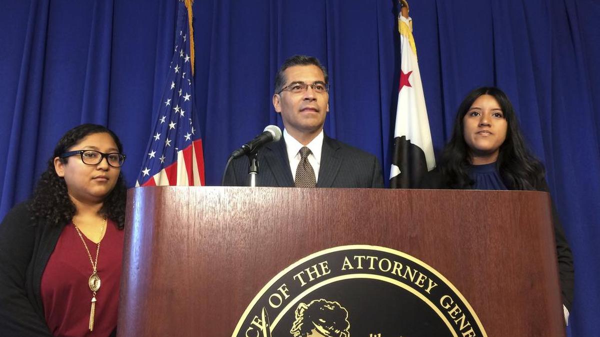 In this Monday, Sept. 11, 2017 photo, California Attorney General Xavier Becerra is flanked by Rosa Barrientos, of East Los Angeles, left, and Eva Jimenez, of Visalia, right, as he announces a lawsuit challenging the Trump administration’s decision to end a program that shields young immigrants from deportation.