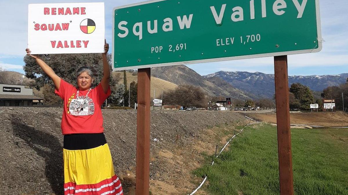 Taweah Garcia holds a sign supporting a campaign to change the name of Squaw Valley in Fresno County. Her sign includes a Native American symbol representing the four directions and people from all nations, she said.